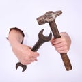 Hammer and wrench in the hand of a girl. Symbol of hard work, feminism and labor day. Isolate on white background