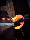 Hammering glowing steel - to strike while the iron is hot. Royalty Free Stock Photo