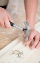 Hammering nails into wooden board