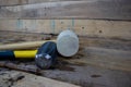 Hammers on a wooden background, a three pound sledge hammer and one rubber mallet