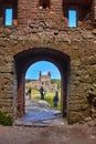 Ruins Blommetarnet tower and some tourists seen through doorway of Hammershus castle - Scandinavia`s largest medieval fortificatio Royalty Free Stock Photo