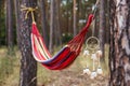 Hammock and dreamcatcher hanging between trees in forest