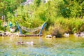 Hammock hanging near Azmak River with white geese, Akyaka, Mugla, Turkey