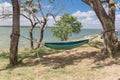 Lakeside hammock hanging between trees with tent