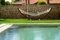 The hammock is on lawn and swimming pool at luxury villa