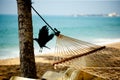 Hammock relaxation on beach with crow and ocean Royalty Free Stock Photo