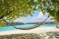 Hammock at the tropical beach with over water bungalows at resort Royalty Free Stock Photo