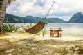 A hammock between two palm trees on the beach. Beautiful beach. The concept of rest and recreation. Beautiful tropical island. Royalty Free Stock Photo