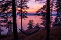 Hammocks and tent on a hill near the lake against the backdrop of a scenic sunset