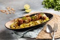 Hamour fish tikka biryani with lime served in dish isolated on table top view of arabic breakfast