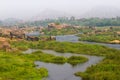 Hampi village Tungabhadra river meadow. Landscape with water, palm, rock, stones. India, Karnataka Royalty Free Stock Photo