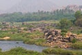 Hampi village Tungabhadra river meadow. Landscape with water, palm, rock, stones. India, Karnataka Royalty Free Stock Photo