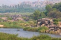 Hampi village Tungabhadra river meadow. Landscape with water, palm, rock, stones. India, Karnataka Royalty Free Stock Photo