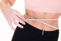 Hand of active slim woman measuring waist over white background wall firm belly with soft tanned skin fit people concept