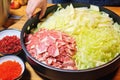 hand adding chili pepper flakes to the cabbage for kimchi