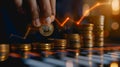 Hand adding gold coin to stack with bright upward trend line Royalty Free Stock Photo