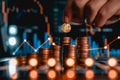 Hand adding gold coin to stack with bright upward trend line Royalty Free Stock Photo