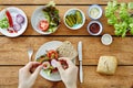 Hand adding ingredients to a fresh organic sandwich Royalty Free Stock Photo