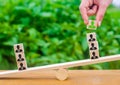 The hand adds a cube with the image of the employee to the stack on the scales. The concept of hiring employees and the appointmen