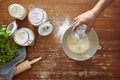 Hand adds water to flour homemade pasta making dough flour