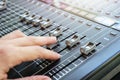 Hand adjusting audio mixer console buttons, faders and sliders. Royalty Free Stock Photo