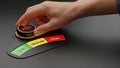 Hand adjusting risk dial to high setting on a dark background with low medium high indicators Royalty Free Stock Photo