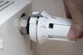 A hand adjusting the temperature control of a radiator heating system in a home setting. This image reflects the importa Royalty Free Stock Photo