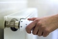 Hand adjusting the valve knob thermostat of heating radiator Royalty Free Stock Photo