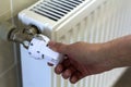 Hand adjusting the valve knob thermostat of heating radiator Royalty Free Stock Photo