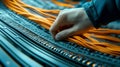 A hand adjusting vibrant orange network cables in a server room, representing connectivity and data management Royalty Free Stock Photo