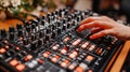 A hand adjusts controls on a professional audio mixer Royalty Free Stock Photo