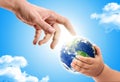 Hand of an adult handing over planet earth to  a baby Royalty Free Stock Photo