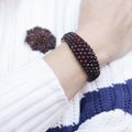 Czech garnet antiques bracelet and brooch on white sweater Royalty Free Stock Photo