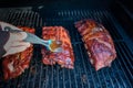 Hand applying sauce to bbq ribs Royalty Free Stock Photo