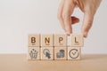 Hand arranged wooden cube blocks with BNPL, alphabets abbreviation , and icon. For buy now pay later online shopping concept Royalty Free Stock Photo
