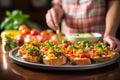 hand arranging bruschetta on a ceramic platter