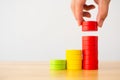 Hand arranging wood block multicolor stacking step as staircase on wooden table