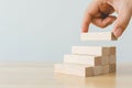 Hand arranging wood block stacking as step stair Royalty Free Stock Photo