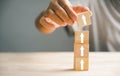 male hands stacking wooden blocks as steps on a white table Royalty Free Stock Photo