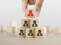 Hand arranging wooden blocks stacking as a pyramid staircase on white background. Leadership, Human resources management, Royalty Free Stock Photo