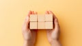 hand arranging wooden cubes on a pastel simple background, providing a mockup for text concept.