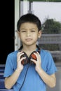Hand asian boy holding headphone on the neck Background blurry