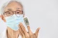 Hand of asian elderly woman with fingertip pulse oximeter on finger,old people measuring heart rate,pulse rate,checking oxygen