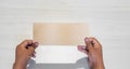 Hand of an Asian man holds blank envelop against white background