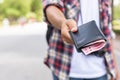 Hand of Asian tourist giving banknote and black wallet that he found in tourist attraction Royalty Free Stock Photo