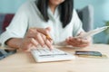 Hand of Asian woman are calculating costs and payment for transactions checking with data from credit cards and account monthly at Royalty Free Stock Photo