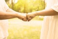 Hand of asian woman senior giving fist bump to hands young women at outdoor in the morning,Cropped image