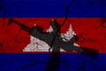Hand assault rifle on the background of the flag of Cambodia and cracks. Cambodia Power Concept
