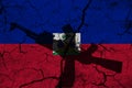 Hand assault rifle on the background of the flag of haiti and cracks. haiti Power Concept