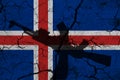 Hand assault rifle on the background of the flag of Iceland and cracks. Iceland Power Concept